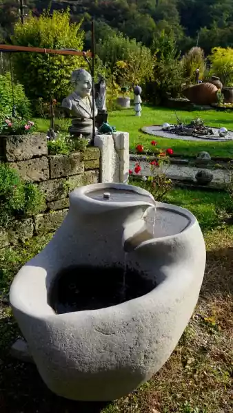 Gartenbrunnen aus einem Porphyr Flussstein mit einem Quellbecken von Steinmetz Jacob aus Neumarkt in Südtirol